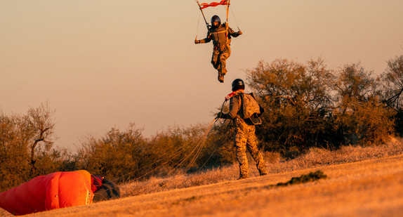 Ein Soldat landet mit seinem Fallschirm.
