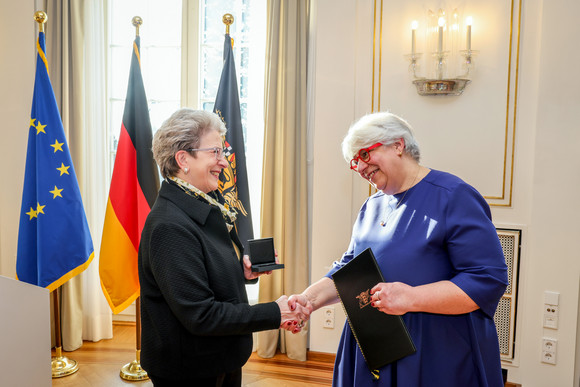 Staatsrätin Barbara Bosch (links) überreicht Irene Armbruster (rechts) die Staufermedaille und eine Urkunde.