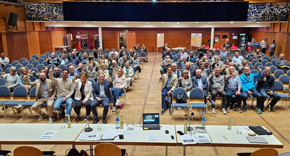 Bürgerinnen und Bürger der Gemeinde Waldbronn sitzen auf Stühlen und zeigen den Daumen nach oben.