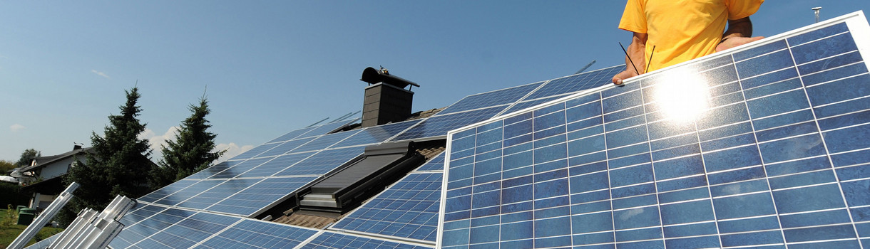 Zwei Monteure einer Firma für Solartechnik installieren auf einem Dach Solarpanele. (Bild: © dpa)