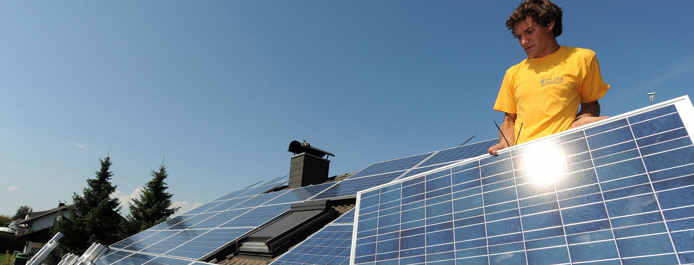 Zwei Monteure einer Firma für Solartechnik installieren auf einem Dach Solarpanele. (Bild: © dpa)