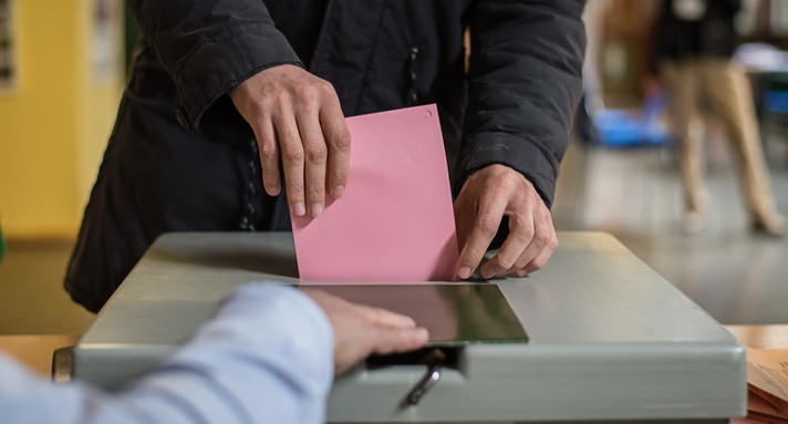 Ein Mann wirft seinen Stimmzettel in die Wahlurne. (Bild: Wolfram Kastl / dpa)