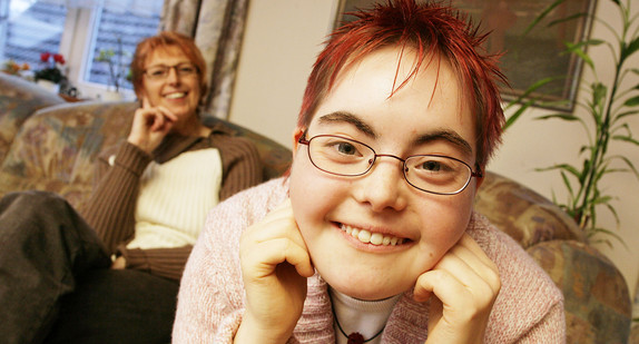 Ein Mädchen mit Downsyndrom lebt mit ihrer Mutter in einem Mehrgenerationenhaus (Symbolbild, © dpa).