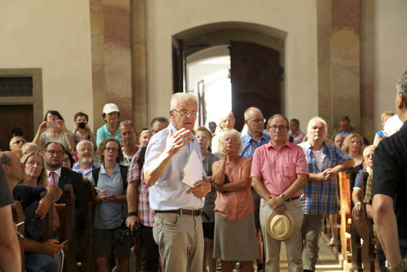 Ministerpräsident Winfried Kretschmann führt die Wandergruppe durch die Basilika Birnau am Bodensee.