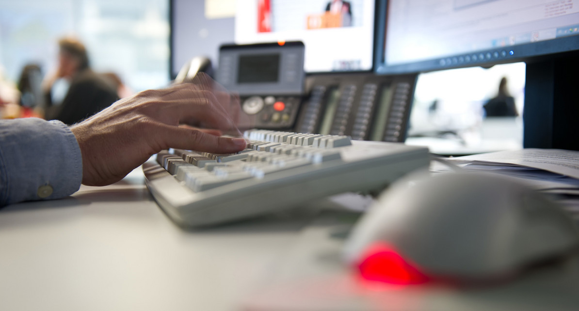 Ein Mann tippt in einem B&uuml;ro auf einer Tastatur.