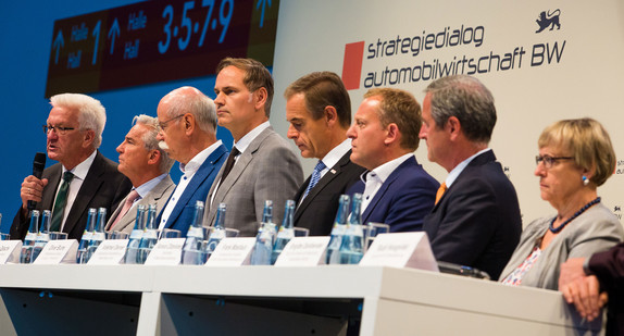 Bei einer Pressekonferenz sprechen (v.l.n.r.) Ministerpräsident Winfried Kretschmann, Innenminister Thomas Strobl, Dieter Zetsche, Vorstandsvorsitzender der Daimler AG, Oliver Blume, Vorstandsvorsitzender der Porsche AG, Volkmar Denner, Geschäftsführer Robert-Bosch GmbH, Roman Zitzelsberger, Bezirksleiter IG Metall Baden-Württemberg, Frank Mastiaux, Vorstandsvorsitzender EnBW Energie Baden-Württemberg AG und Brigitte Dahlbender vom BUND über die erste Zwischenbilanz des Strategiedialogs Automobilwirtschaft BW. (Foto: © dpa)