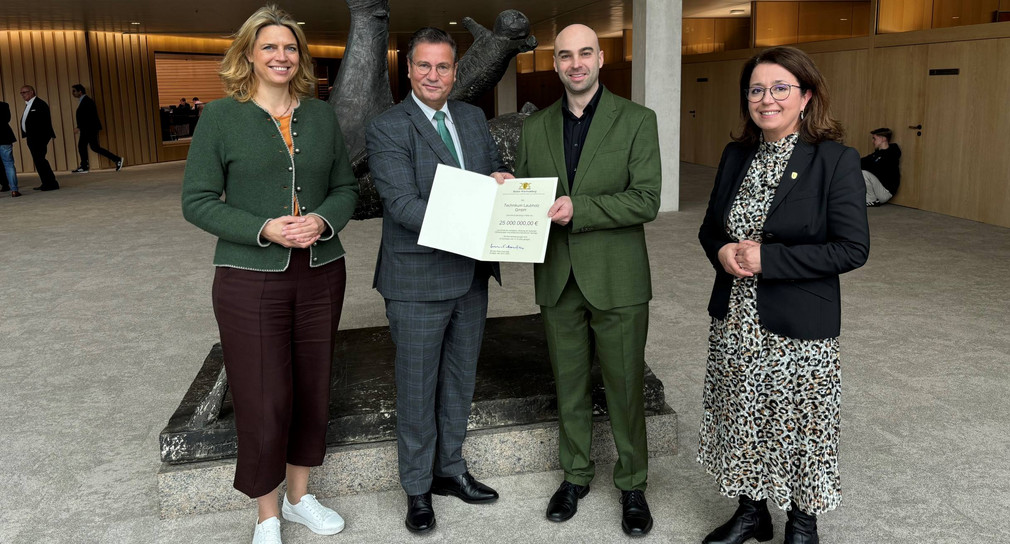 Minister Peter Hauk (Zweiter von links) übergibt den Förderbescheid an Dr. Tobias Wolfinger (Zweiter von rechts), Geschäftsführer der Technikum Laubholz GmbH.