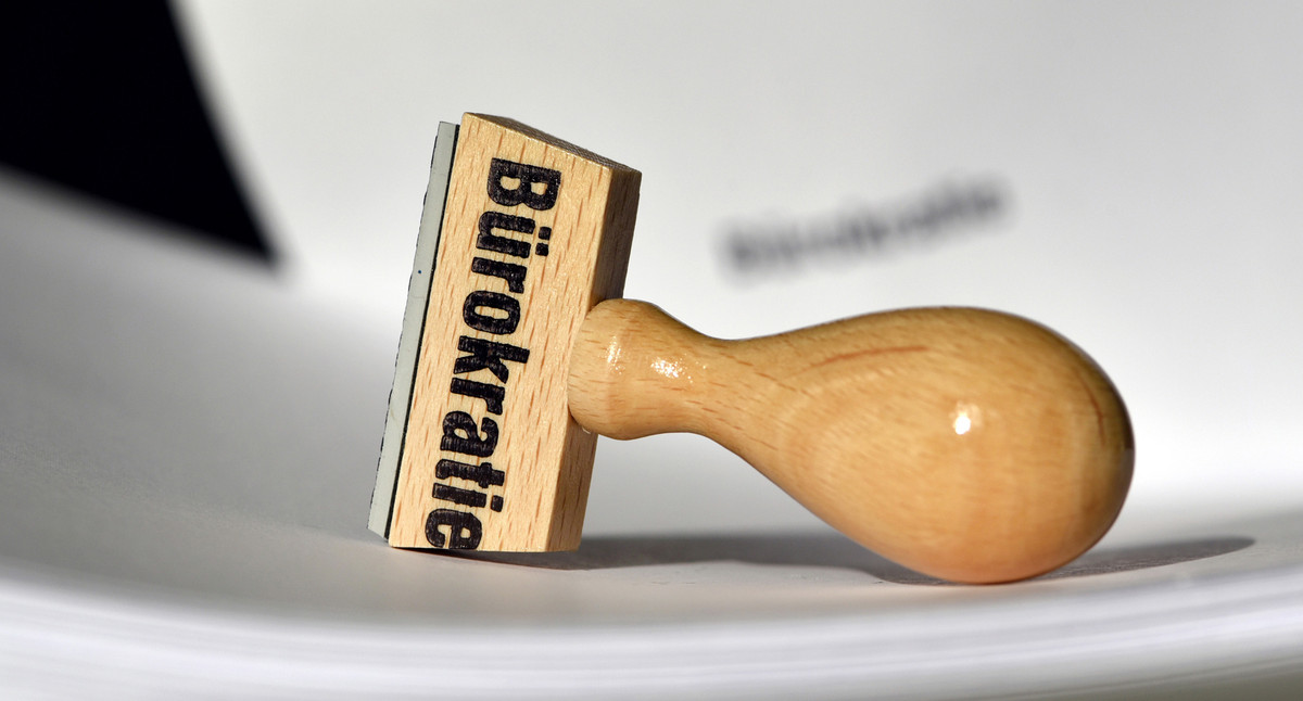 Ein Stempel mit der Aufschrift &amp;quot;Bürokratie&amp;quot; liegt auf Papieren.