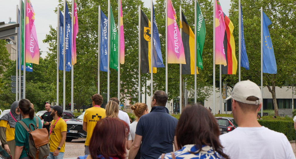 Etwa ein Dutzend Besucher der Futorumundo vor Werbefahnen der Veranstaltung. 