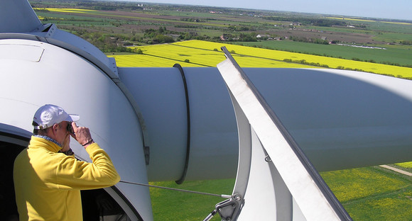 Ein Mann steht auf der Kanzel einer Windkraftanlage. (Bild: © Windstrom Vindvet)