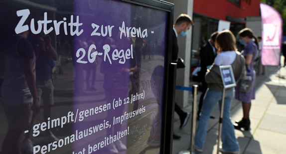 Vor einem Veranstaltungsort steht ein 2G-Hinweisschild.