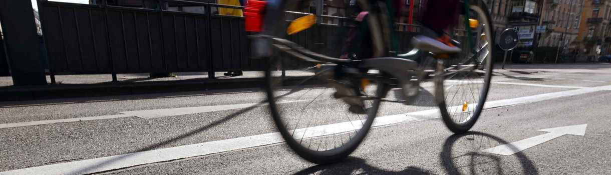 In der Innenstadt fährt ein Radfahrer auf einem Fahrradstreifen.