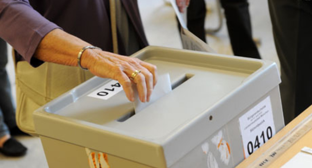 Eine Frau wirft ihren Wahlzettel in die Wahlurne (Bild: dpa).