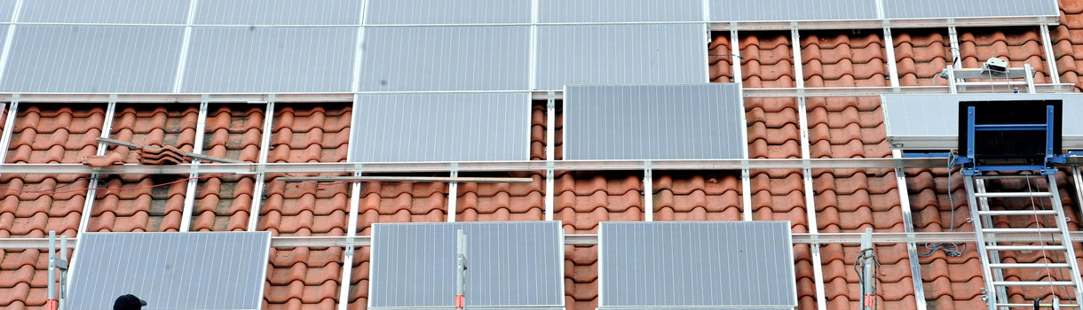 Ein Arbeiter installiert in St. Peter im Hochschwarzwald auf dem Dach eines Kleinunternehmens eine Solaranlage. (Bild: dpa)
