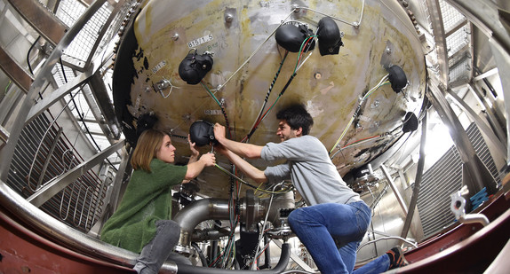 Mitarbeiter des Bereichs der atmosphärischen Aerosolforschung beim Karlsruher Institut für Technologie (KIT) arbeiten im Wolkenlabor an der Anlage für Aerosol Interaktionen und Dynamik in der Atmosphäre (AIDA). (Foto: dpa)
