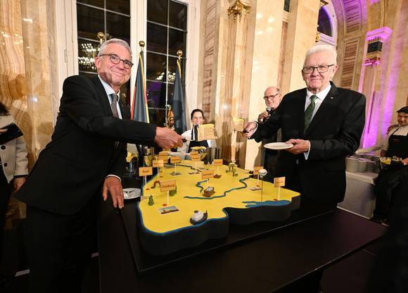 Ministerpräsident Winfried Kretschmann (rechts) und Innenminister Thomas Strobl (links) beim Anschnitt einer großen Baden-Württemberg-Torte 