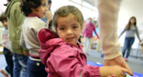 Ein Flüchtlingskind aus Syrien spielt in einem Kindergarten (Bild: © dpa).
