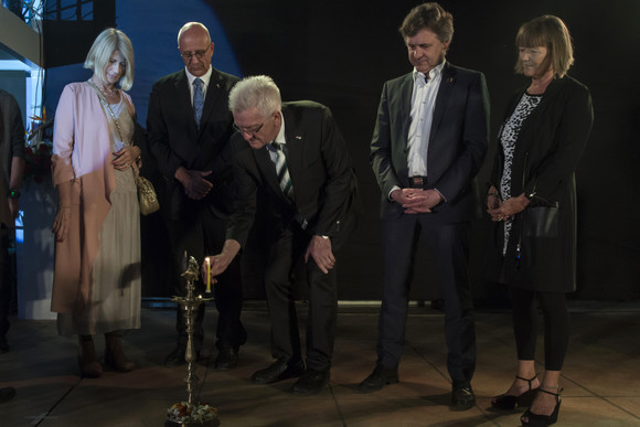 Ministerpräsident Winfried Kretschmann (M.) beim Anzünden eines 4-gliedrigen Kerzenständers bei einem Abendempfang im Goethe-Institut in Pune im Rahmen der Partnerschaft Baden-Württemberg – Maharashtra