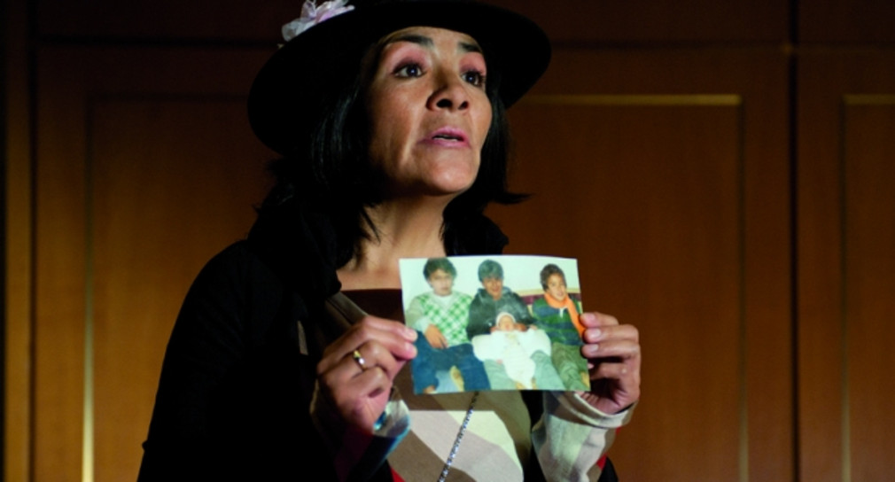 Szene aus dem Theaterstück „Bürgerbeteiligung - Ein Lustspiel“: Eine Darstellerin zeigt ein Foto „ihrer“ Kinder.