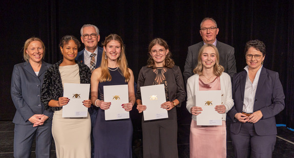 von links nach rechts: Präsidentin des Landesjustizprüfungsamtes Sintje Leßner, Noemi Jahli Anika-Avallone, Rektor Frank Haarer, Nicole Linder, Franziska Maria Martin, Kira Aileen Nußbaumer und Prorektor Rainer Hock, Ministerin der Justiz und für Migration Marion Gentges