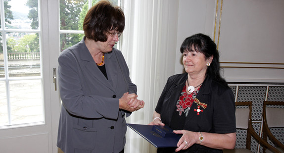 Die Staatsrätin für Zivilgesellschaft und Bürgerbeteiligung, Gisela Erler (l.) überreicht Irmgard Reister (r.) am 3. Juni 2013 in der Villa Reitzenstein in Stuttgart das Verdienstkreuz am Bande des Verdienstordens der Bundesrepublik Deutschland.