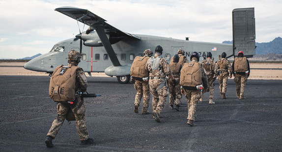 Mehrere Soldaten gehen zu einem Flugzeug.