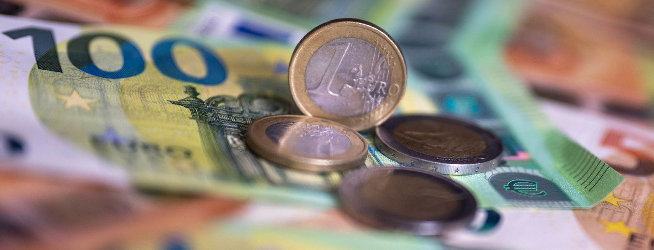 Geldscheine mit dem Wert von 100 und 50 Euro und Münzen liegen auf einem Tisch.
