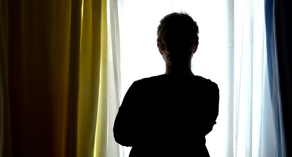 Eine Frau schaut aus einem Fenster. Eine Frau schaut aus einem Fenster.