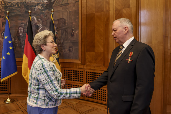 Die Staatsrätin für Zivilgesellschaft und Bürgerbeteiligung, Barbara Bosch (links), überreicht Prof. Dr. Bernd Kühlmuß (rechts) das Bundesverdienstkreuz. 