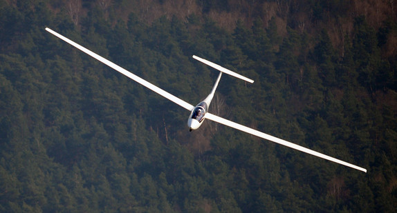 Ein Segelflugzeug kreist über einem kleinen Flugplatz. (Bild: dpa)