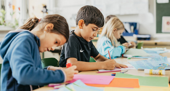 Schülerinnen und Schülern sitzen in einem Klassenzimmer.