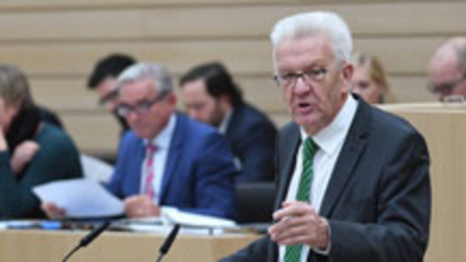 Kretschmann steht am Rednerpult im sanierten Landtag von Baden-Württemberg (Bild © dpa).
