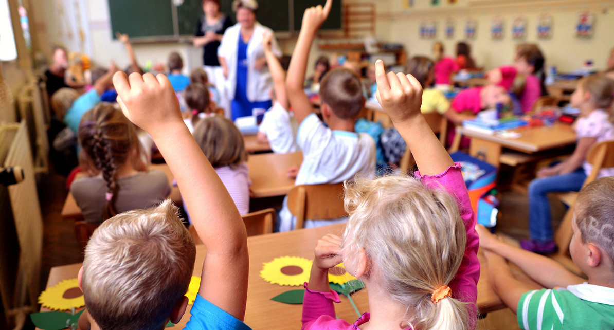 Sch&uuml;ler einer Grundschule melden sich im Unterricht (Bild: &copy; dpa).