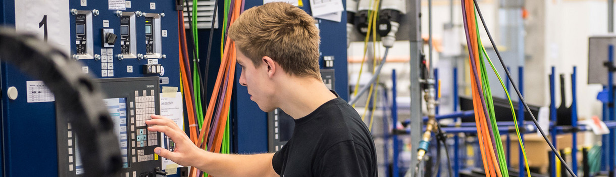 Ein Produktionstechnologe in Ausbildung arbeitet an einem Simulator für die Bewegungseinheit eines Laser. (Foto: © dpa)