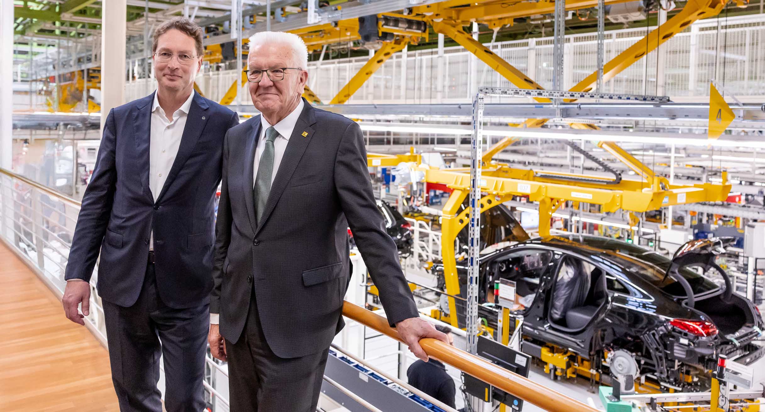 Ola Källenius (links), Vorsitzender des Vorstands der Mercedes-Benz Group AG, und Ministerpräsident Winfried Kretschmann (rechts) stehen in der Montagehalle des neuen CLA in Rastatt.