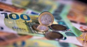 Geldscheine mit dem Wert von 100 und 50 Euro und M&uuml;nzen liegen auf einem Tisch.