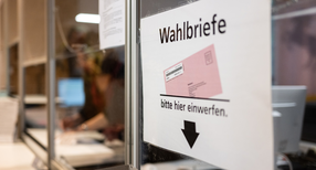 Ein Schild weist in einem Wahlb&uuml;ro auf eine Wahlurne f&uuml;r die Briefwahl  hin.